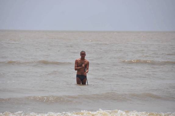 Entrando no mar de água doce com uma vara para se proteger das arraias, na Ilha de Marajó - PA